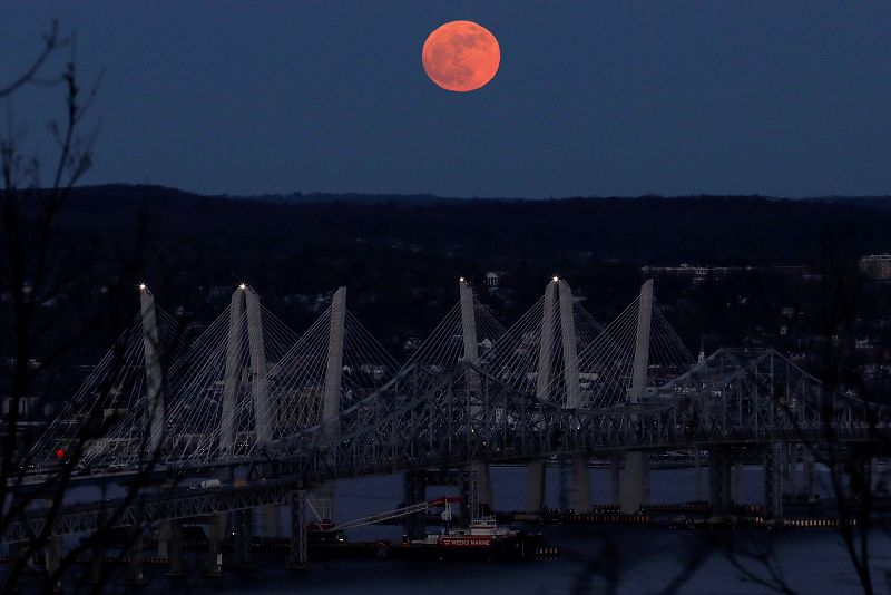 La Luna llena fotografiada sobre el río Hudson y el Puente Mario M. Cuomo, en la ciudad estadounidense de Nueva York.