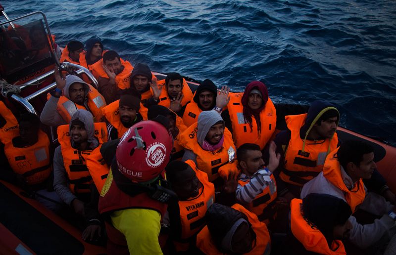 Agradecidos, dicen adiós con la mano a los voluntarios desde la lancha rápida que les lleva hasta el Aquarius