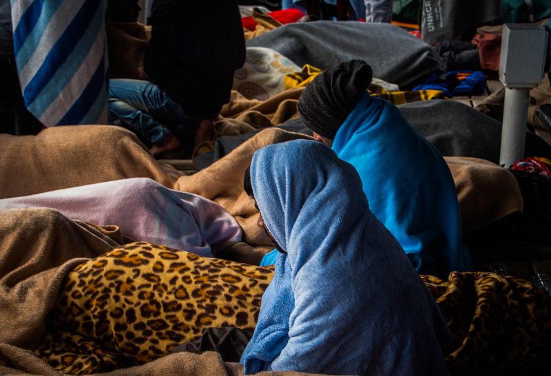 Dos hombres mirando al infinito mientras todos duermen en la cubierta del OPEN ARMS