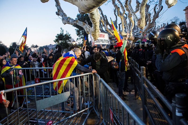 Los manifestantes tratan de derribar las vallas que protegen el Parlament