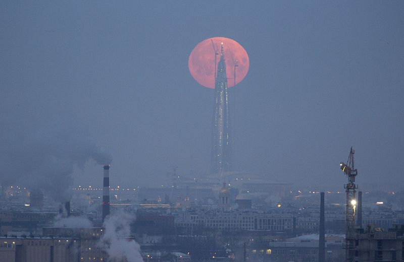 La Luna llena aparece detrás de la torre Lakhta Centre, que está construyéndose en la ciudad rusa de San Petersburgo.