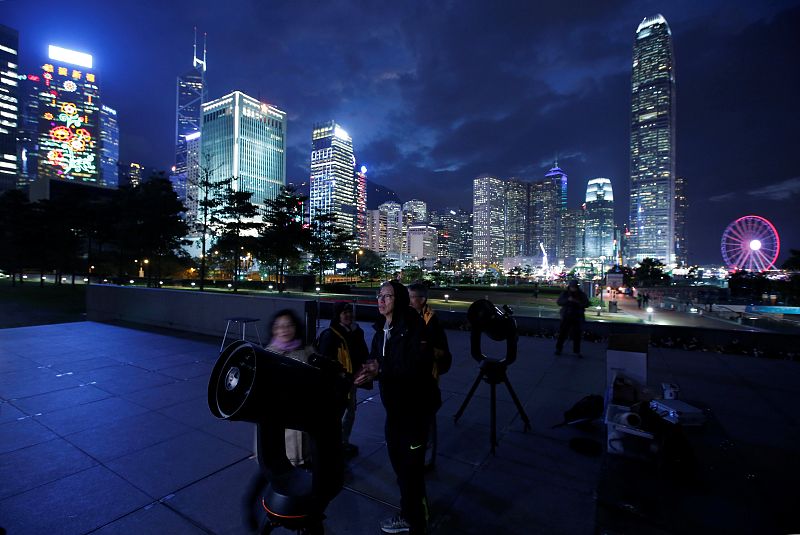 Aficionados a la astronomía colocan sus telescopios para observar el eclipse de superluna azul en Hong Kong.