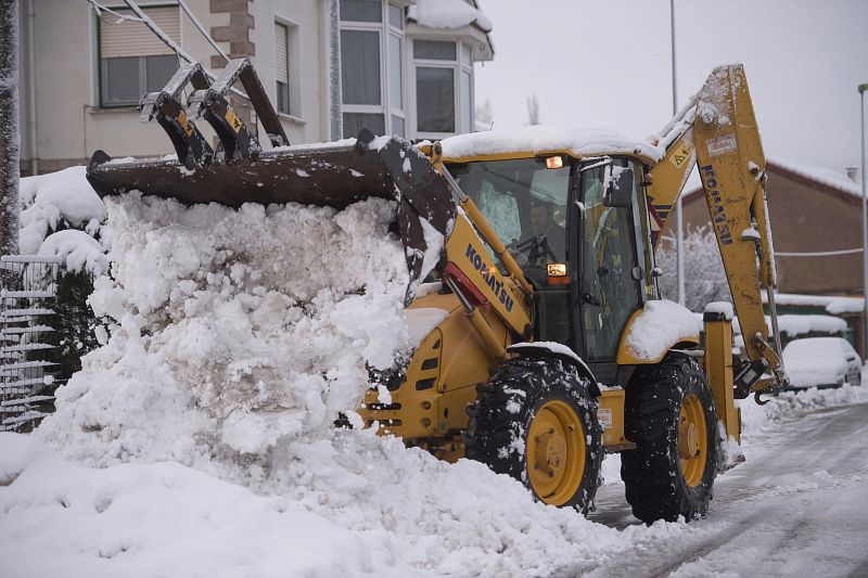 Una excavadora limpia una calle de nieve en la localidad cántabra de Reinosa
