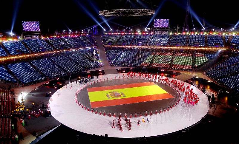 La bandera de España en el centro del Estadio Olímpico mientras los atletas españoles desfilan.