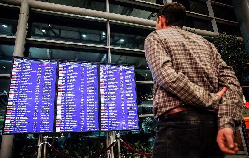 Un hombre mira un panel de vuelos en el aeropuerto Domodédovo de Moscú