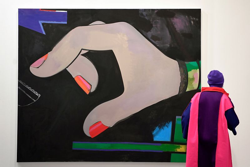Una mujer observa un lienzo de la artista Ellen Berkenblit