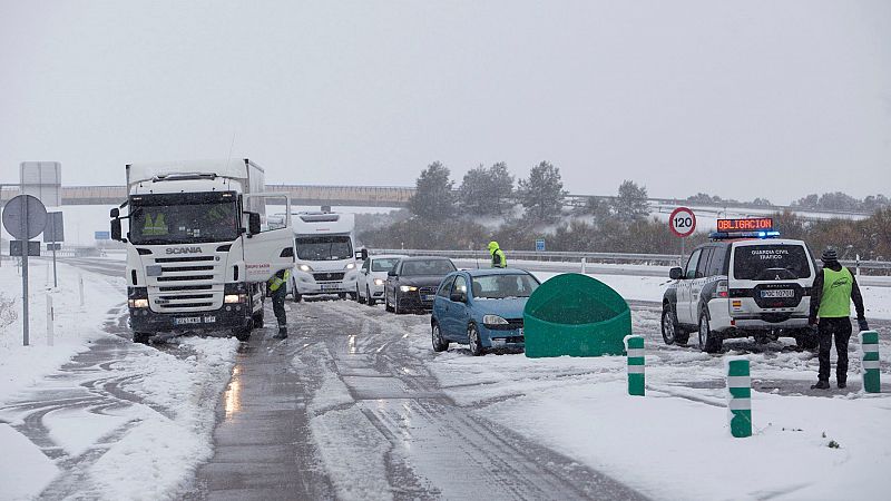 Una patrulla de Tráfico de la Guardia Civil en la autopista A-23, en Huesca, informa a los conductores del uso obligatorio de cadenas