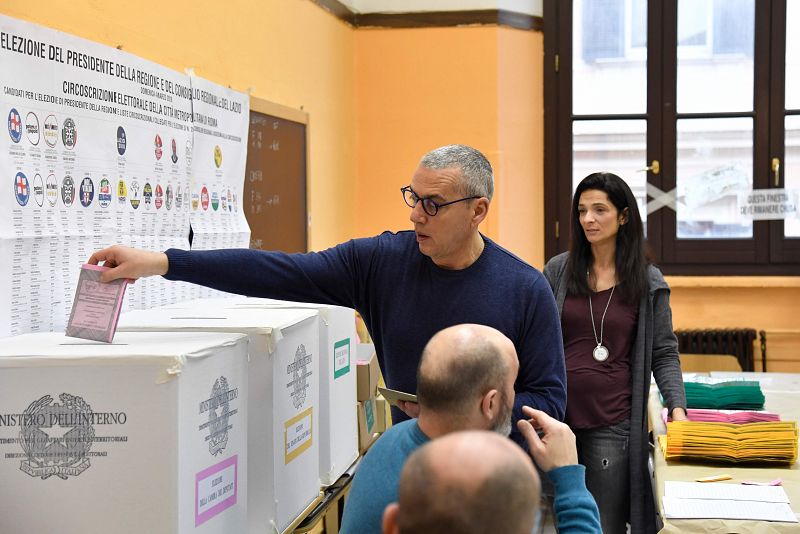 Un miembro de la mesa electoral introduce el voto de un elector en las urnas