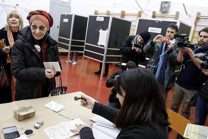 Emma Bonino, delante de la mesa, espera su turno para votar en las elecciones italianas
