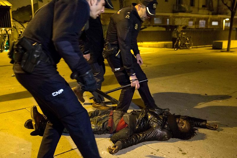 Agentes de la Policía junto a uno de los manifestantes, que está tendido en el suelo