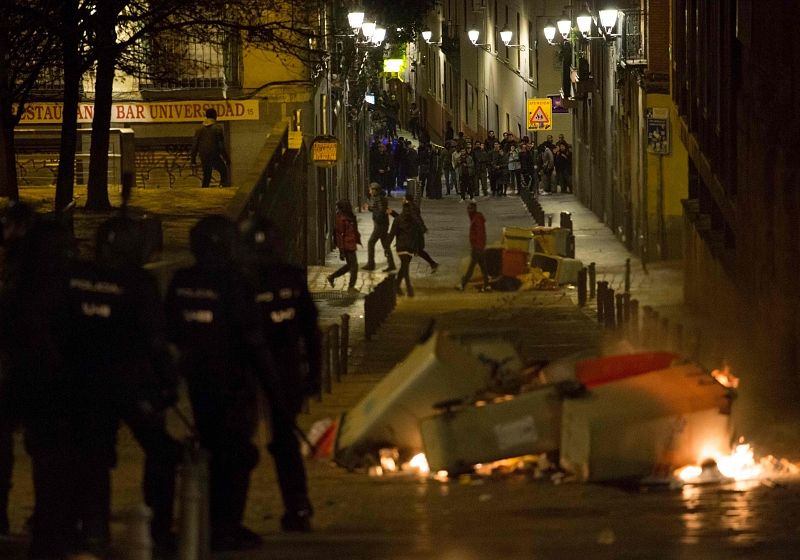 Policías y manifestantes en los disturbios por las calles del barrio desencadenados por la muerte de un mantero por un infarto