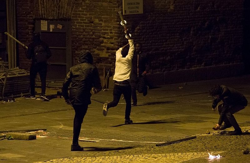 Uno de los manifestantes corre sujetando una barra de metal