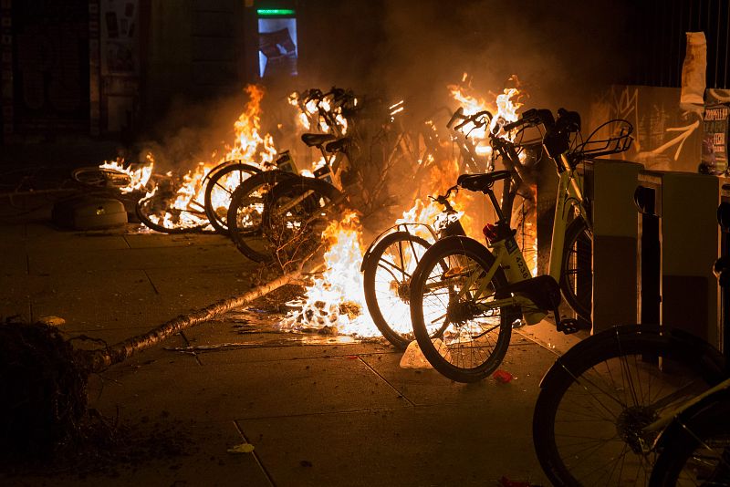 Varias bicicletas de servicio público arden en uno de los estacionamientos del barrio de Lavapiés por los disturbios