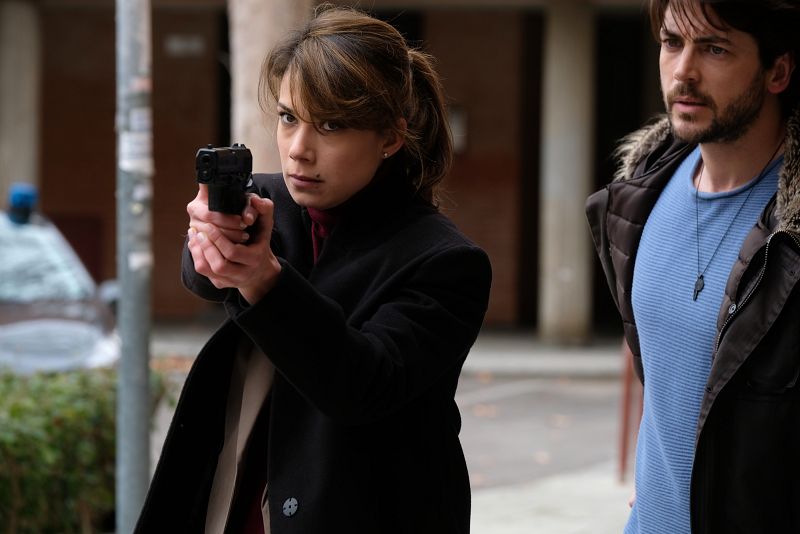 Alicia apuntando con una pistola a alguien