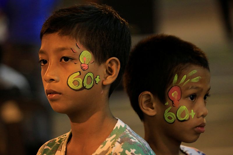 Dos niños en la ciudad de Cavite, Filipinas, con el número 60 pintado en sus rostros