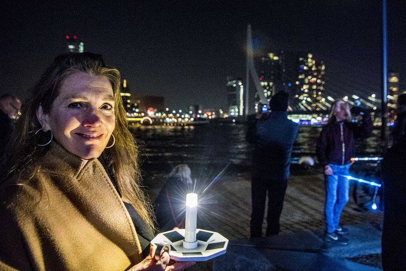 Una mujer con una vela encendida en el Puente de Erasmo en la ciudad holandesa de Róterdam
