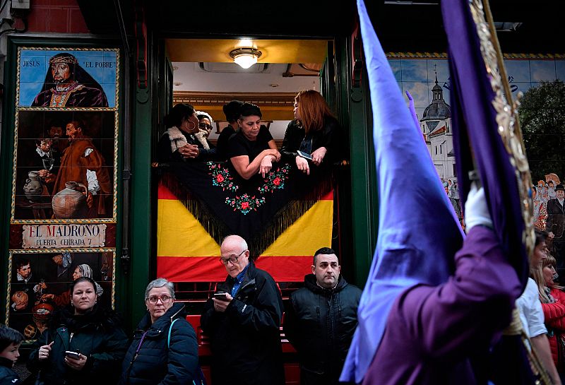 La gente observa la procesión de "Jesús Nazareno, el pobre y María Santísima del Dulce Nombre" por las calles del centro de Madrid.