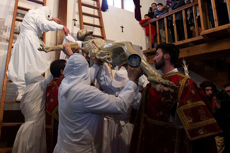 Varios cofrades realizan el Descendimiento, dentro de la iglesia de San Mamés debido a la meteorología adversa, que ha obligado a suspender el desfile del Santo Entierro