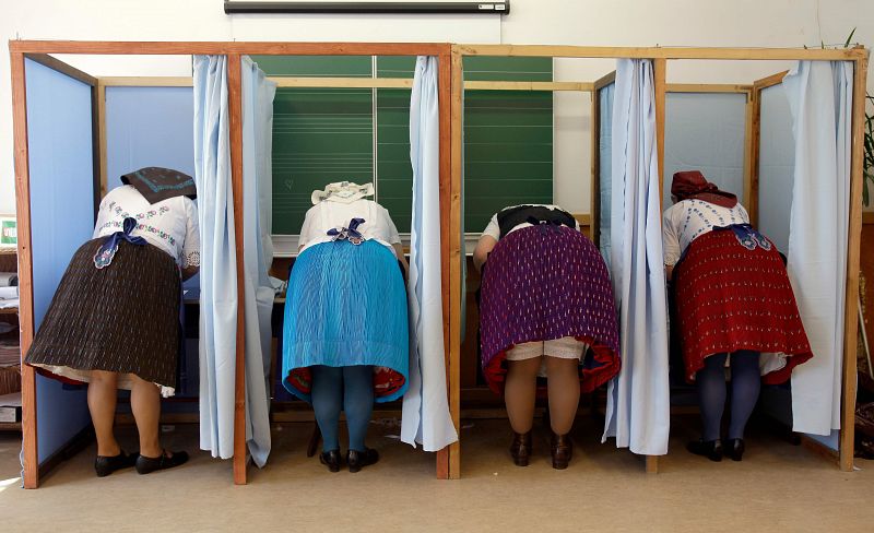 Mujeres vestidas con el traje tradicional húngaro preparan sus votos en un colegio electoral en Veresegyház, unos 30 kilómetros al este de Budapest