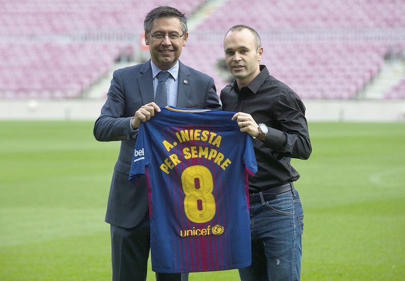 Iniesta (d) y el presidente del FC Barcelona , Josep Maria Bartomeu (i), posan tras anunciarse la renovación "de por vida" en 2017.