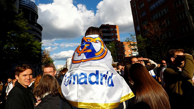 Un niño enfundado con la bandera del Real Madrid en los alrededores del estadio merengue.