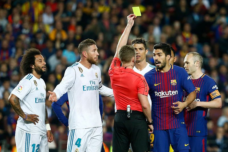 El árbitro Hernández Hernández muestra cartulina a Luis Suárez y Sergio Ramos.