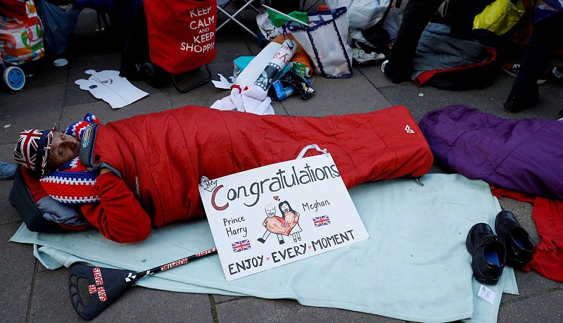 A spectator in a sleeping bag lays on the pavement ahead of the wedding between Britainâ¿¿s Prince Harry and Meghan Markle in, Windsor