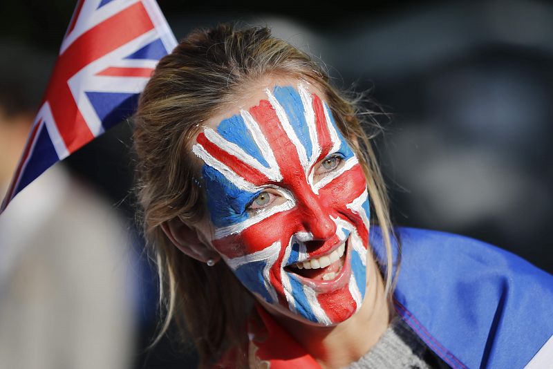 Una mujer espera a los novios con la cara pintada con la bandera de Reino Unido