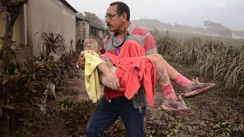 Un hombre rescata a una niña afectada por la erupción de 'Fuego' en El Rodeo