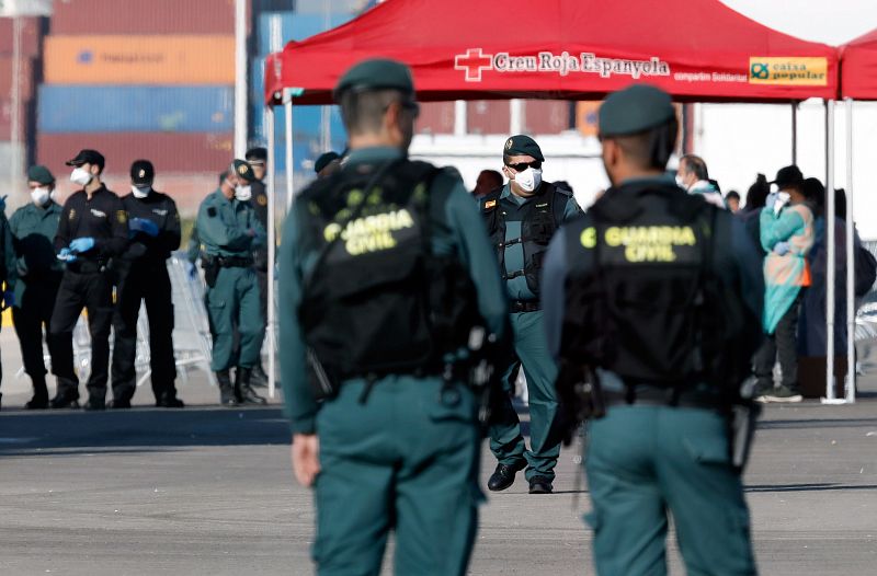 Efectivos de Guardia Civil esperan el desembarco de los primeros inmigrantes en el puerto valenciano