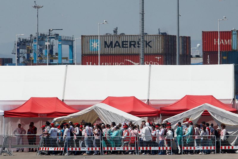 Miembros de la Cruz Roja atienden a los migrantes que han llegado al puerto