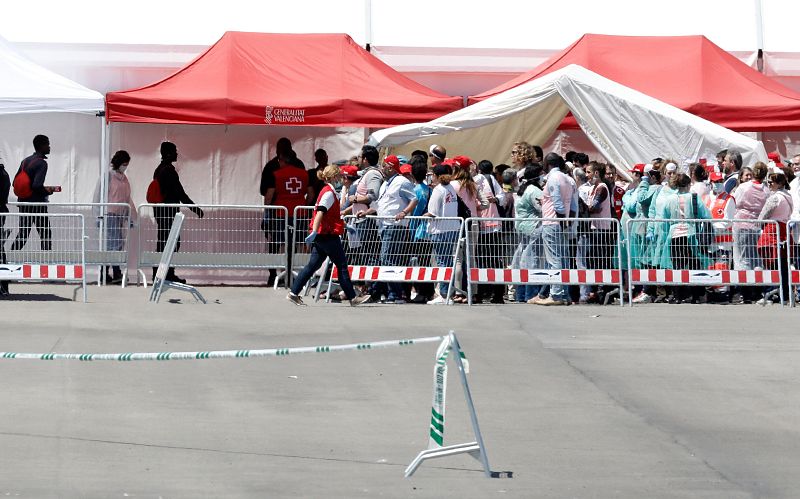 Varios de los 106 inmigrantes que viajaban en el Aquarius, esperan ser atendidos tras la llegada del buque al puerto de Valencia