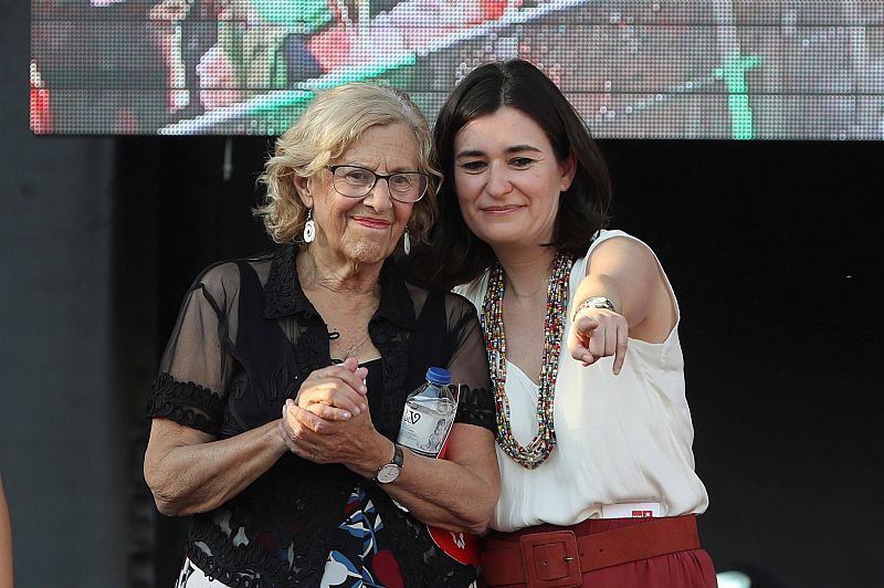 La alcaldesa de Madrid, Manuela Carmena, junto a la ministra de Sanidad, Carmen Montón en el escenario instalado en la plaza de Colón de Madrid donde ha finalizado la manifestación del Orgullo