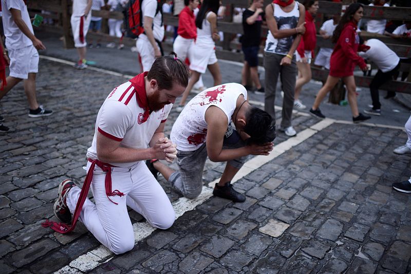 Runners pray before the bull run on the fourth day of the San Fermin festival in Pamplona