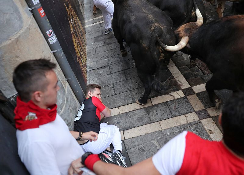 Revellers try to avoid bulls during the sixth running of the bulls of the San Fermin festival in Pamplona