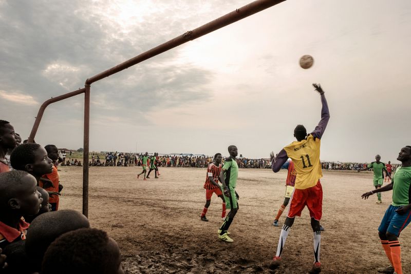 Unos chicos se entretienen al atardecer jugando al fútbol en el campo de Bentiu