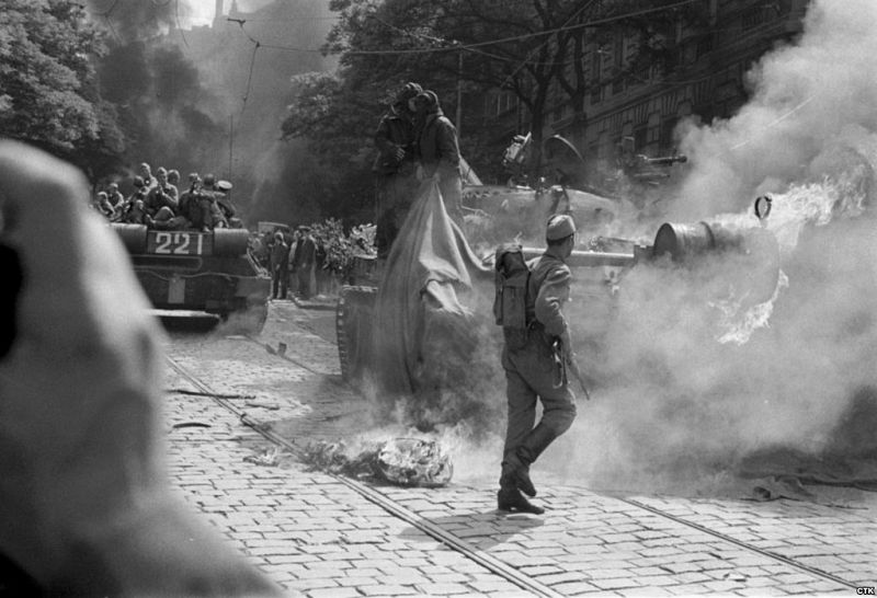 Varios soldados soviéticos tratan de apagar el fuego provocado en uno de sus tanques por los manifestantes