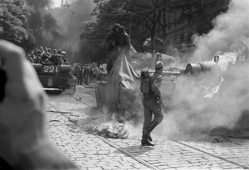 Varios soldados soviéticos tratan de apagar el fuego provocado en uno de sus tanques por los manifestantes