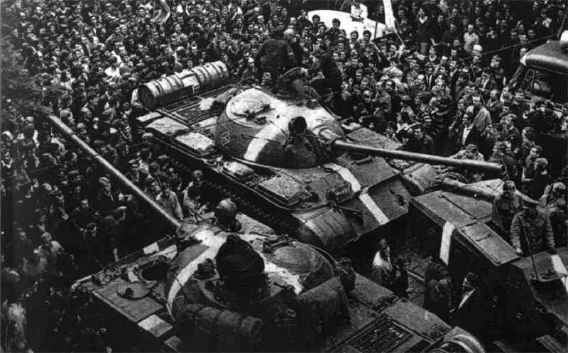 Cientos de manifestantes rodean varios tanques soviéticos T-55 pintados con rayas blancas para diferenciarlos de los del mismo tipo que usaban las fuerzas checoslovacas.