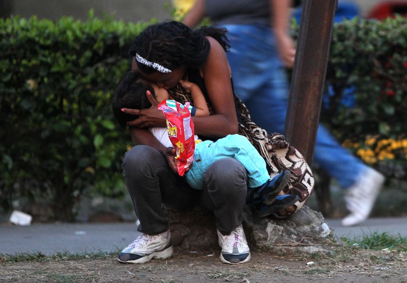 Una mujer venezolana abraza un niño en una calle de Cali (Colombia)