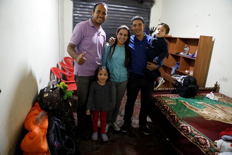 El migrante venezolano Nelson Gil y su familia posan para una foto en un alojamiento temporal en el distrito Independencia en Lima, Perú