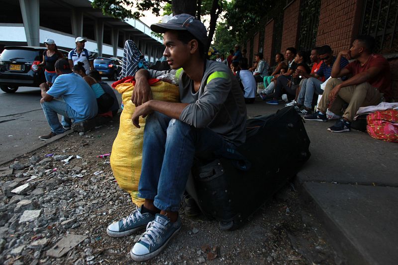 Un venezolano descansa sobre una maleta en una calle de Cali (Colombia)
