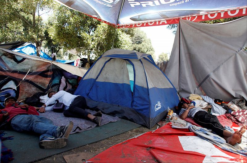 Migrantes venezolanos descansan en un campamento de tiendas de campaña en Quito, Ecuador