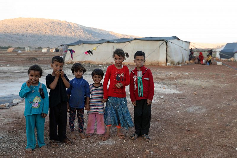 Niños pequeños posan en un campo de desplazados próximo a la frontera de Siria con Turquía