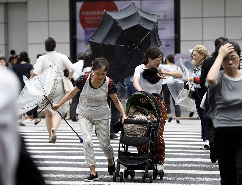 Peatones con paraguas en Tokio luchan contra los fuertes vientos del tifón