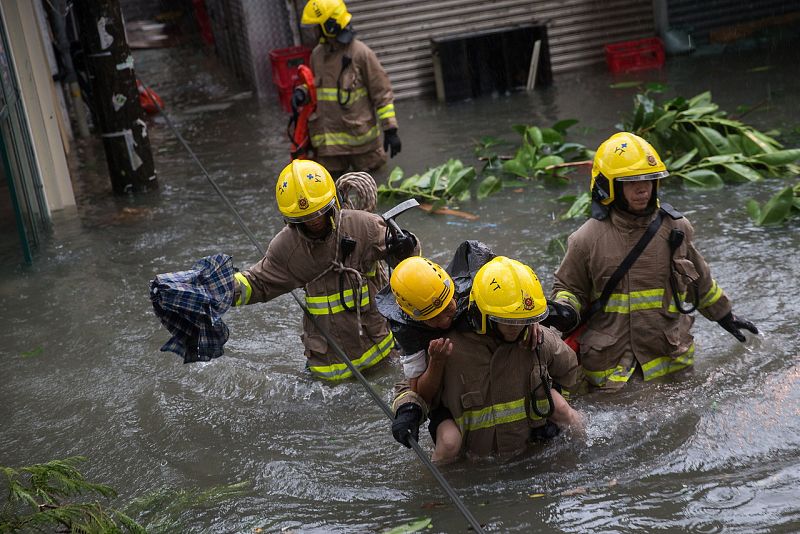 Efectivos de emergencias rescatan a una mujer de una calle inundada en Hong Kong. EFE/EPA/JEROME FAVRE