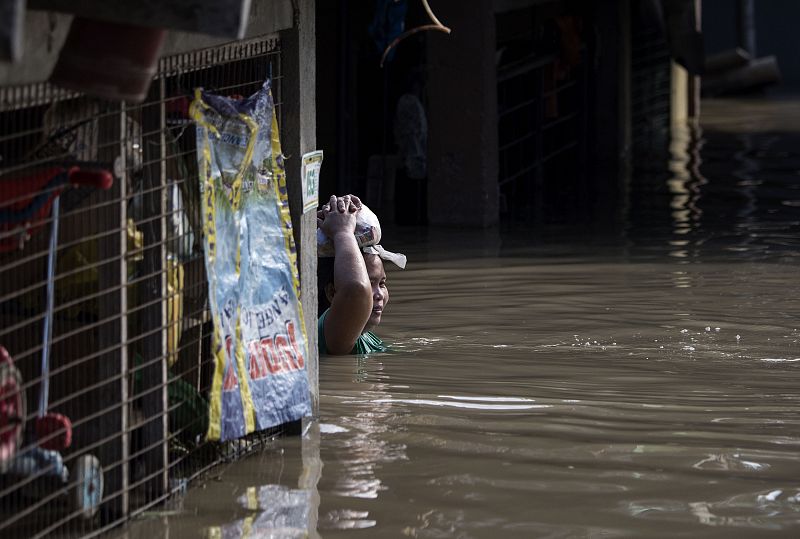 Una mujer se desplaza por una calle inundada en Calumpit