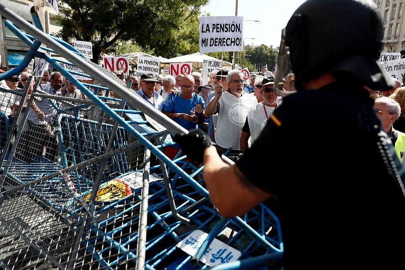 Agentes antidisturbios han impedido que los pensionistas sobrepasaran las vallas que cierran la Plaza de las Cortes y llegaran ante las puertas del Congreso. Efe/Mariscal