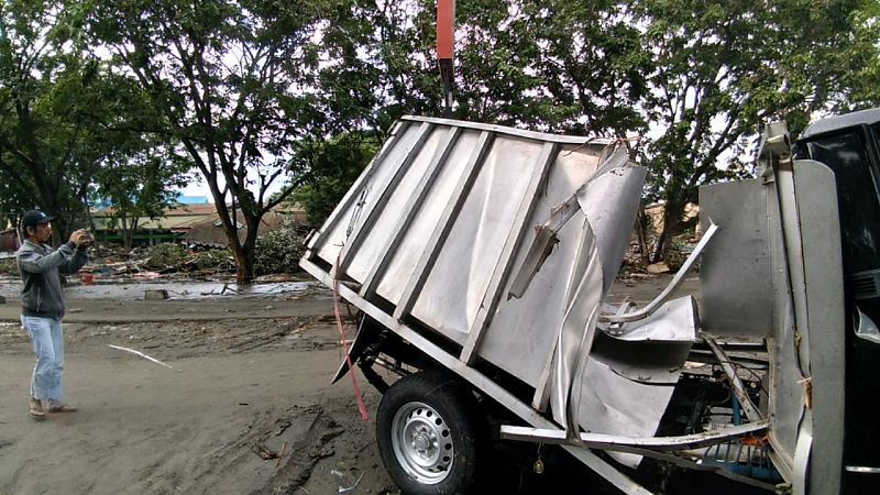 Un hombre toma una fotografía de los destrozos provocados por el terremoto-tsunami en Palu