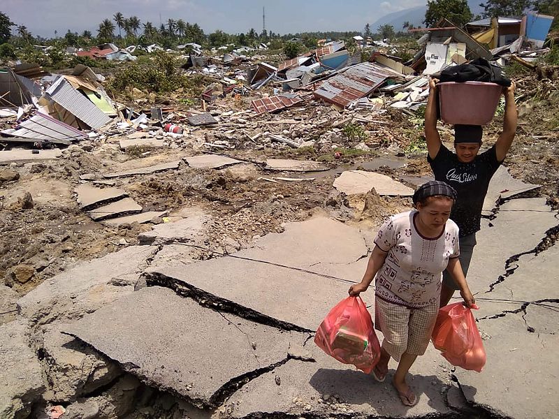 Dos residentes de Palu con algunas de las pertenencias que han podido recuperar tras la catástrofe que ha golpeado la isla